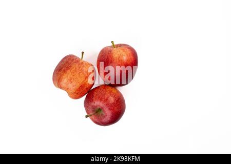 Trois pommes sur fond blanc. Trois pommes rouges sucrées sur un fond blanc sans couture Banque D'Images
