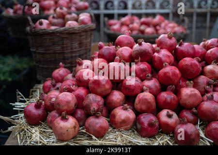Récolte de grenade mûre sur paille sèche sur le marché agricole extérieur en Turquie. Des aliments sains végétariens Banque D'Images