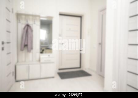 Couloir dans l'appartement, arrière-plan flou. Petit hall d'entrée dans des tons beiges clairs, arrière-plan flou. Hall d'appartement défoqué Banque D'Images