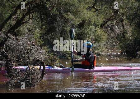 Un concurrent protégé conduisant un bateau sur une rivière Banque D'Images