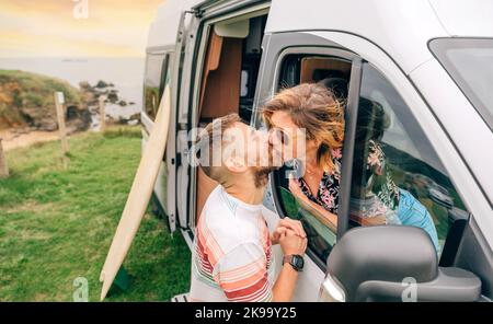 Couple embrassant à travers la fenêtre de la camionnette de camping pendant un voyage Banque D'Images