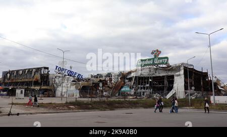 Butscha, Ukraine. 21st octobre 2022. Les passants à pied, devant un centre commercial détruit dans la guerre, dans la petite ville ukrainienne de Butscha. Peu d'endroits en Ukraine sont devenus autant un symbole de la brutalité de la guerre d'agression russe que Butscha. Plus d'un demi-an après le retrait des forces d'occupation, les résidents reprennent leur vie quotidienne. Pour beaucoup, cependant, la guerre est loin d'être terminée. Credit: Hannah Wagner/dpa/Alay Live News Banque D'Images