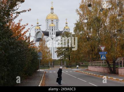 Butscha, Ukraine. 21st octobre 2022. Les passants marchent à pied devant une église sur les motifs de laquelle les résidents qui sont morts pendant l'occupation russe ont été enterrés dans une fosse commune. Peu d'endroits en Ukraine sont devenus autant un symbole de la brutalité de la guerre d'agression russe que Butscha. Plus d'un demi-an après le retrait des forces d'occupation, les résidents reprennent leur vie quotidienne. Pour beaucoup, cependant, la guerre est loin d'être terminée. Credit: Hannah Wagner/dpa/Alay Live News Banque D'Images