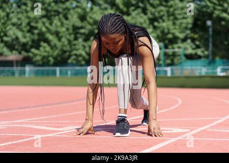 Athlète de fille noire se prépare à courir pour fixer un nouveau record ou un entraînement cardio-vasculaire quotidien en plein air Banque D'Images