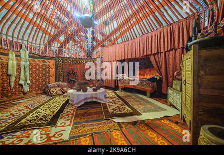 Vue intérieure d'un modèle à grande échelle d'une yourte, avec de nombreux tapis riches, un lit et d'autres articles de maison habituels. Au Musée national de la République de Banque D'Images