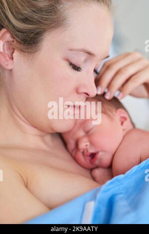 C'est un rêve devenu réalité : une belle jeune mère et sa jeune fille qui vient de naître dorment ensemble dans un lit d'hôpital. Banque D'Images