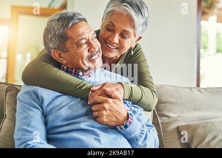 Il n'y a pas de place ID plutôt être. Un couple affectueux de personnes âgées se détendant sur un canapé ensemble à la maison. Banque D'Images