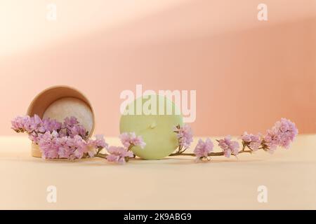 shampooing plein au soleil avec fleurs roses séchées. Bar écologique sur fond clair. Soins capillaires Banque D'Images