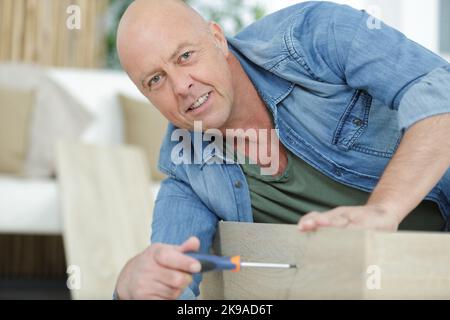 homme mature assemblant des meubles plats Banque D'Images