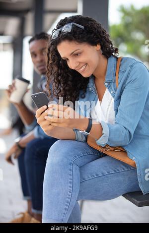 femme utilise un smartphone dans une gare Banque D'Images