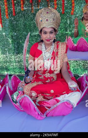 Une jeune femme hindoue attirante habillée comme Lakshmi et assise dans un lotus. Au Diwlai 2022 à Queens, New York. Banque D'Images