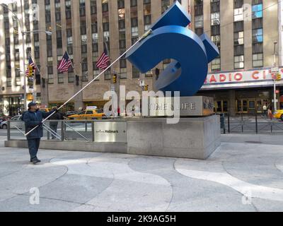 Un homme d'entretien nettoie la sculpture à l'extérieur du bâtiment Time & Life sur 6th avenue et 50th rue à Manhattan. Ils ont depuis déménagé au centre-ville. Banque D'Images