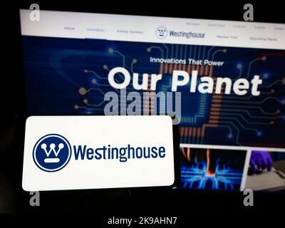 Personne tenant un smartphone avec le logo de Westinghouse Electric Company LLC sur l'écran devant le site Web. Mise au point sur l'affichage du téléphone. Banque D'Images