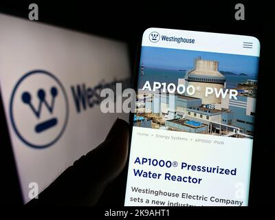 Personne tenant un téléphone cellulaire avec le site Web de Westinghouse Electric Company LLC à l'écran devant le logo d'affaires. Concentrez-vous sur le centre de l'écran du téléphone. Banque D'Images