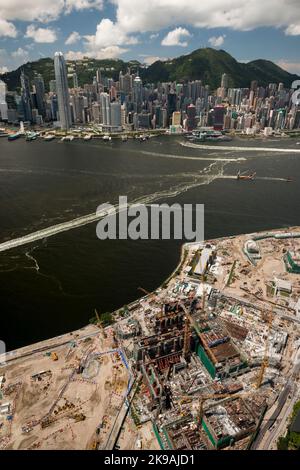 Vue aérienne du musée M+, dans le quartier culturel de West Kowloon, en construction en 2017, avec l'île de Hong Kong visible de l'autre côté du port de Victoria Banque D'Images