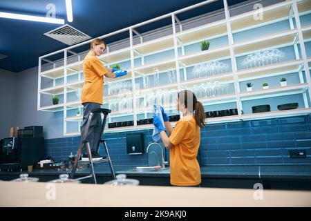 Les femmes nettoyage entreprise effectue le nettoyage général dans la cuisine Banque D'Images