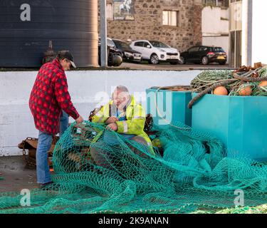 26 octobre 2022. Fraserburgh, Aberdeenshire, Écosse. Il s'agit de deux hommes qui sont en train de réparer un grand filet de pêche sur la jetée de Fraserburgh Harb Banque D'Images