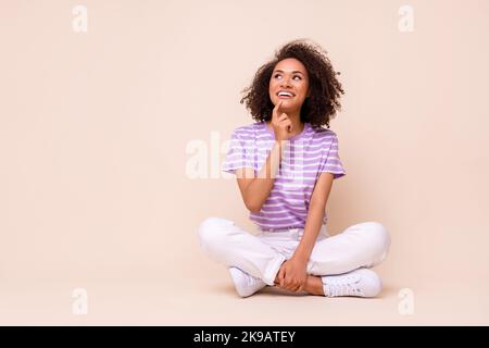 Photo pleine grandeur de jeune adorable magnifique belle femme assise rêveuse à propos de nouveau petit ami look vide espace isolé sur fond beige couleur Banque D'Images