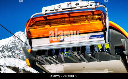 TATRANSKA LOMNICA, SLOVAQUIE - 12 MARS 2022 : les skieurs assis sur les chaises de remontée mécanique de la station Tatranska Lomnica, dans les montagnes des Hautes Tatras, Slovaquie Banque D'Images