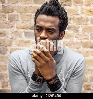 Émotions et expressions : anxiété. Une expression inquiète sur le visage d'un jeune homme piquant ses ongles. À partir d'une série d'images associées. Banque D'Images