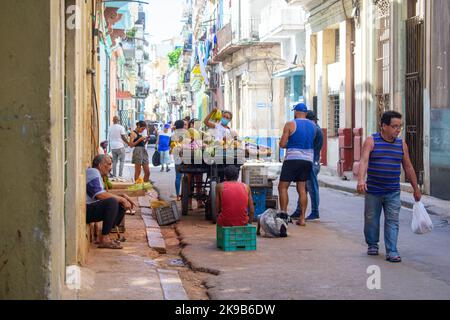 Les gens qui marchent à côté d'un stand de fruits et légumes dans une petite rue de la Vieille Havane. Banque D'Images