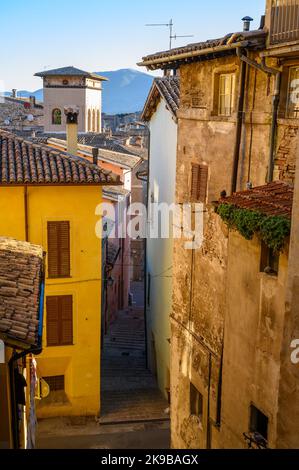 Une scène de rue typique dans la vieille ville de Spoleto avec des maisons traditionnelles en pierre et des ruelles étroites photographiées tôt le matin. Ombrie, Italie. Banque D'Images