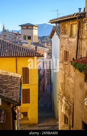 Une scène de rue typique dans la vieille ville de Spoleto avec des maisons traditionnelles en pierre et des ruelles étroites photographiées tôt le matin. Ombrie, Italie. Banque D'Images