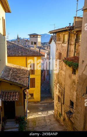 Une scène de rue typique dans la vieille ville de Spoleto avec des maisons traditionnelles en pierre et des ruelles étroites photographiées tôt le matin. Ombrie, Italie. Banque D'Images