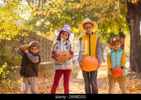 Enfants cueillant et sculptant des citrouilles dans une ferme de campagne Banque D'Images