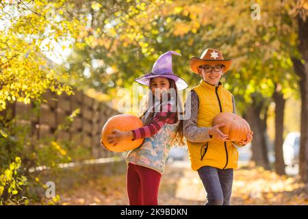 Enfants cueillant et sculptant des citrouilles dans une ferme de campagne Banque D'Images