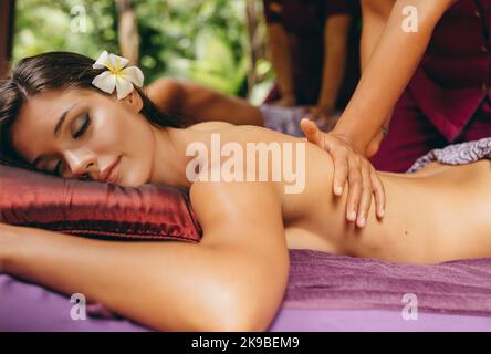 Gros plan d'une jeune femme recevant un massage du dos au spa de jour. Belle femme recevant un massage au centre de santé de la station. Banque D'Images