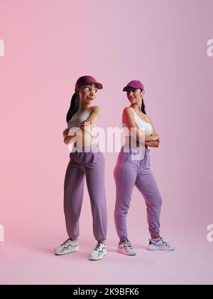 jeune femme sportive debout à côté de son avatar métaverse dans un studio. Heureuse jeune femme souriant à la simulation 3D d'elle-même. Jeune femme joyeuse Banque D'Images