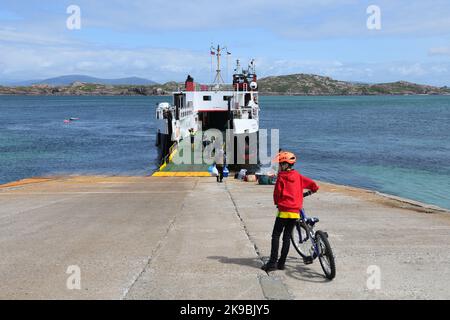 Le passager uniquement Caledonian MacBrayne car ferry au slip sur l'île d'Iona, Inner Hebrides, Écosse. Un garçon attend de monter à bord du voyage de retour à Mu Banque D'Images