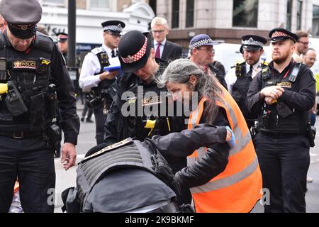 Londres, Angleterre, Royaume-Uni. 27th octobre 2022. La police de la ville de Londres arrête un activiste pendant la manifestation. Les activistes du climat de Just Stop Oil ont bloqué la jonction entre Queen Victoria Street et Cannon Street dans la City de Londres. Les activistes exigent de mettre fin à toutes les licences futures pour l'exploration et le développement des combustibles fossiles au Royaume-Uni. (Image de crédit : © Thomas Krych/ZUMA Press Wire) Banque D'Images