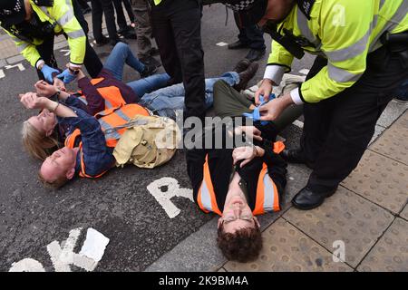 Londres, Angleterre, Royaume-Uni. 27th octobre 2022. Met la police arrête un activiste pendant la manifestation. Les activistes du climat de Just Stop Oil ont bloqué la jonction entre Queen Victoria Street et Cannon Street dans la City de Londres. Les activistes exigent de mettre fin à toutes les licences futures pour l'exploration et le développement des combustibles fossiles au Royaume-Uni. (Image de crédit : © Thomas Krych/ZUMA Press Wire) Banque D'Images