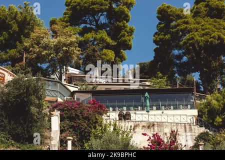 Corfou, Grèce 2022.10.04. Un café-bâtiment avec une terrasse sur la colline à proximité des arbres verts et des buissons colorés. Banque D'Images