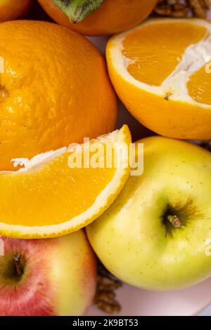 Les oranges, les tranches d'orange et les pommes en gros plan. Banque D'Images
