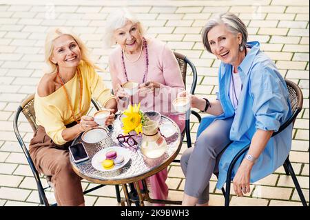 Groupe de femmes adultes âgées belles et heureuses datant de plein air et de réunion au bar cafétéria, ayant un parler - élégant à la mode vieux peopl mature Banque D'Images