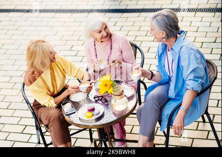 Groupe de femmes adultes âgées belles et heureuses datant de plein air et de réunion au bar cafétéria, ayant un parler - élégant à la mode vieux peopl mature Banque D'Images