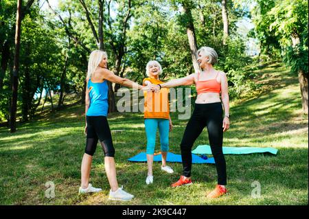 Groupe de belles sportives senior femmes d'entraînement en plein air - adultes adultes âgés amis faisant des exercices d'entraînement de forme physique dans un parc pour rester en bonne santé et f Banque D'Images