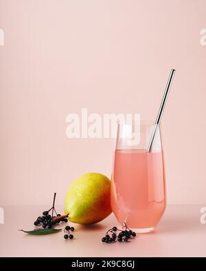 Boisson aux baies de sureau, cocktail avec poire sur fond coloré. Banque D'Images