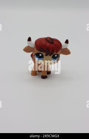 Petit animal en plastique mignon sur fond blanc. Figurine de magasin d'animaux de compagnie la plus volumineuse isolée de collection avec une grande tête et de grands yeux. Banque D'Images