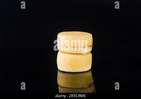 Beaucoup de différentes sortes de têtes de fromage sur table sombre. Têtes de fromage dures moyennes sur planche à découper en bois. Concept de saine alimentation biologique. Fromage fait à la main Banque D'Images