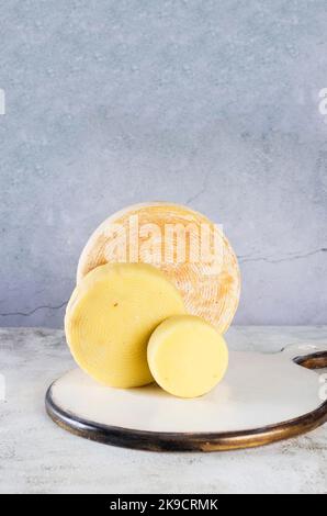 Pile de têtes de fromage de différents types empilées sur une table. Têtes de fromage dures moyennes sur planche à découper en bois. Concept de saine alimentation biologique. CH. Fait à la main Banque D'Images