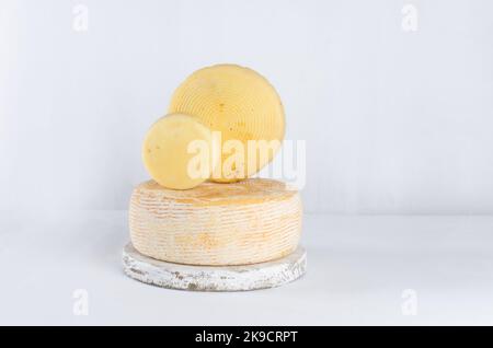 Pile de têtes de fromage de différents types empilées en ligne verticale sur la table. Têtes de fromage dures moyennes sur planche à découper en bois. Alimentation biologique saine conc Banque D'Images