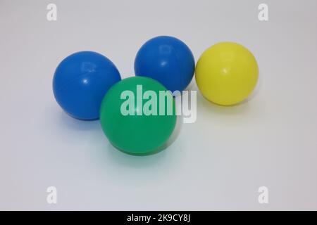 Boules en plastique colorées sur fond blanc Banque D'Images