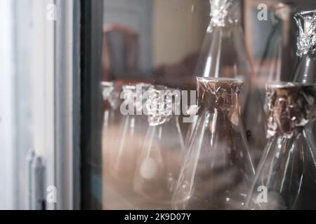 Vider le flacon Erlenmeyer dans un placard sur une étagère. Flacon conique avec film au lieu d'un couvercle dans un laboratoire Banque D'Images