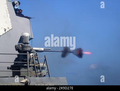 Un système de canon MK-38 25mm est tiré au cours d'un exercice de tir en direct à bord du destroyer de missile guidé USS Mason (DDG 87). Marine américaine. Le système de mitrailleuse Mark 38 25 mm (MGS) est un système d'armes de bord conçu pour protéger les navires de guerre principalement contre une variété de menaces de surface, en particulier les petites embarcations rapides. Il se compose d'un pistolet à chaîne M242 Bushmaster monté sur une tourelle qui peut être commandée manuellement ou à distance, selon la variante. Banque D'Images