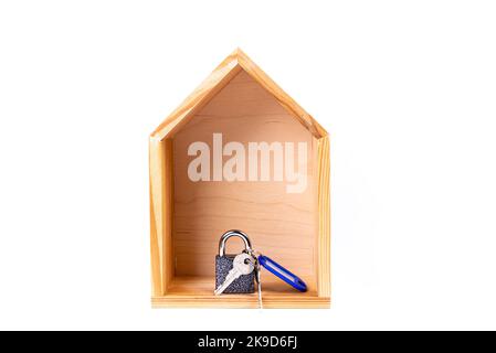 Symbole maison avec clé métallique sur fond blanc. Immobilier, concept d'assurance, hypothèque, acheter maison de vente, concept de realtor. Isolé, maison en bois, Banque D'Images