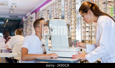 Une femme optométriste teste la vue du garçon Banque D'Images